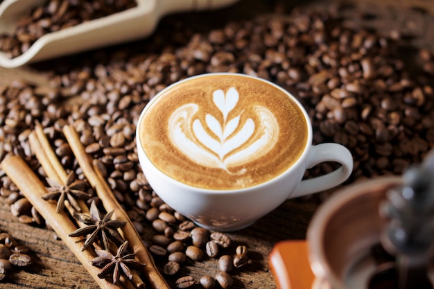 White coffee cup and roasted coffee beans around