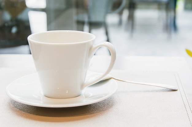 White coffee cup on wood table in cafe