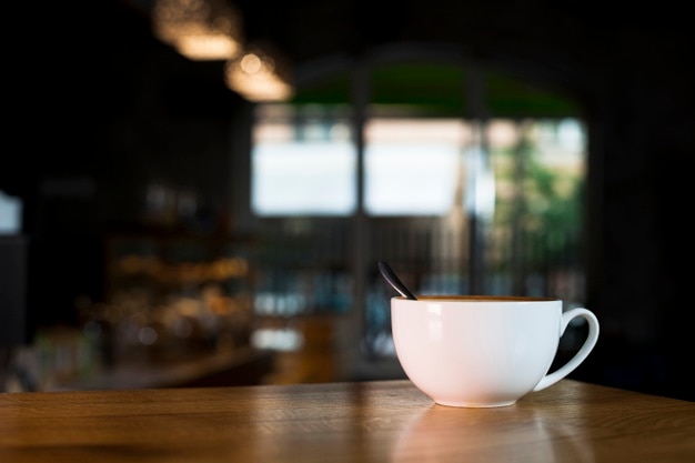 Photo white coffee cup over wooden desk in coffee shop