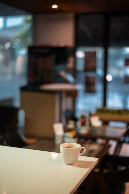 White coffee mug on the table inside the cafe