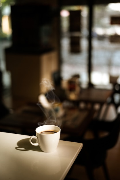 White coffee mug on the table inside the cafe