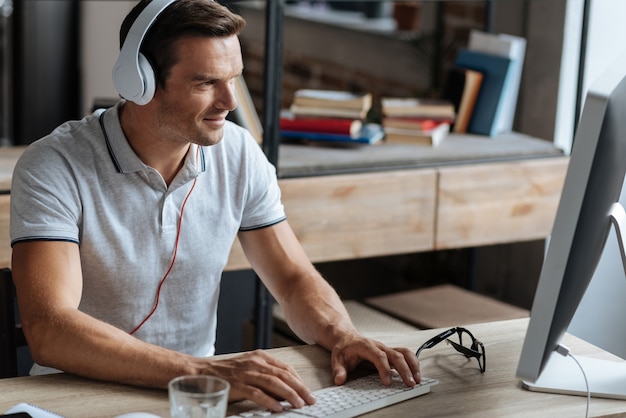 White collar. Wonderful handsome cheerful guy wearing headphones