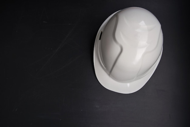 White color hardhat against chalkboard