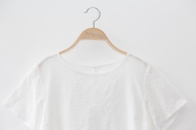 White colour blouse is clothes hanger on white backgroundclose up