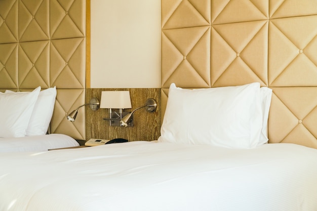 White comfortable pillow on bed decoration in hotel bedroom