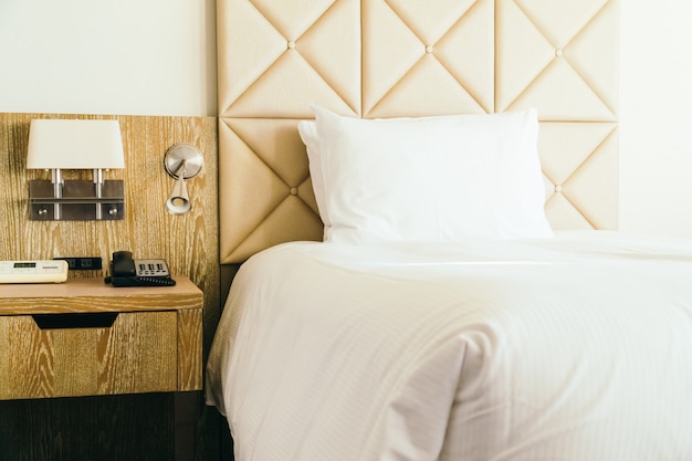 White comfortable pillow on bed decoration in hotel bedroom