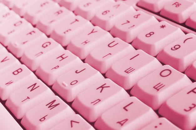 Photo white computer keyboard image toned in viva magenta color of the 2023 year