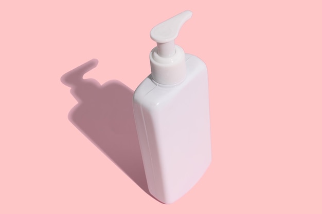 White container for shampoo lotion cleaner On a pink background With hard shadow