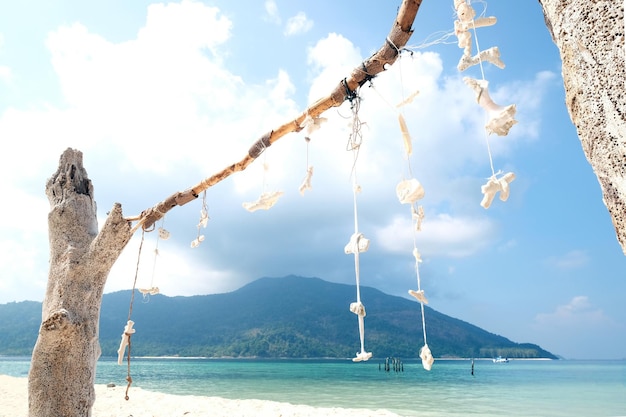 흰색 끈으로 묶인 흰색 산호와 조개껍질이 해변 태국 관광 개념을 장식합니다.
