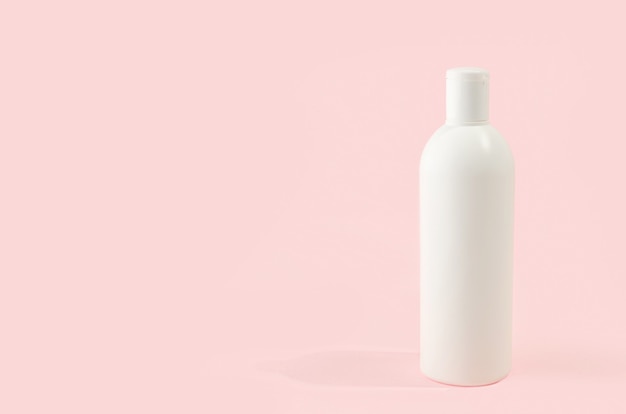 White  cosmetic bottle on pink