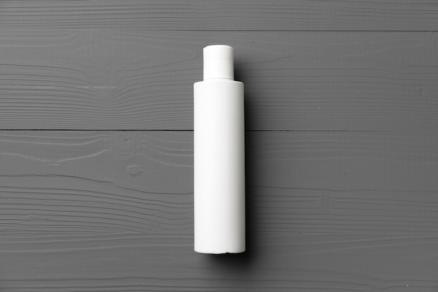 Photo white cosmetic container on gray wooden background top view