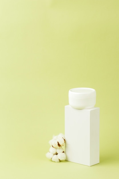 White cosmetic cream jar on stand