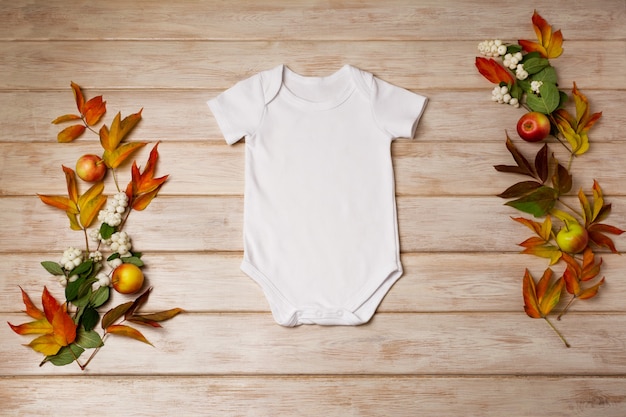 Photo white cotton baby short sleeve onesie mockup with snowberry red and green fall leaves