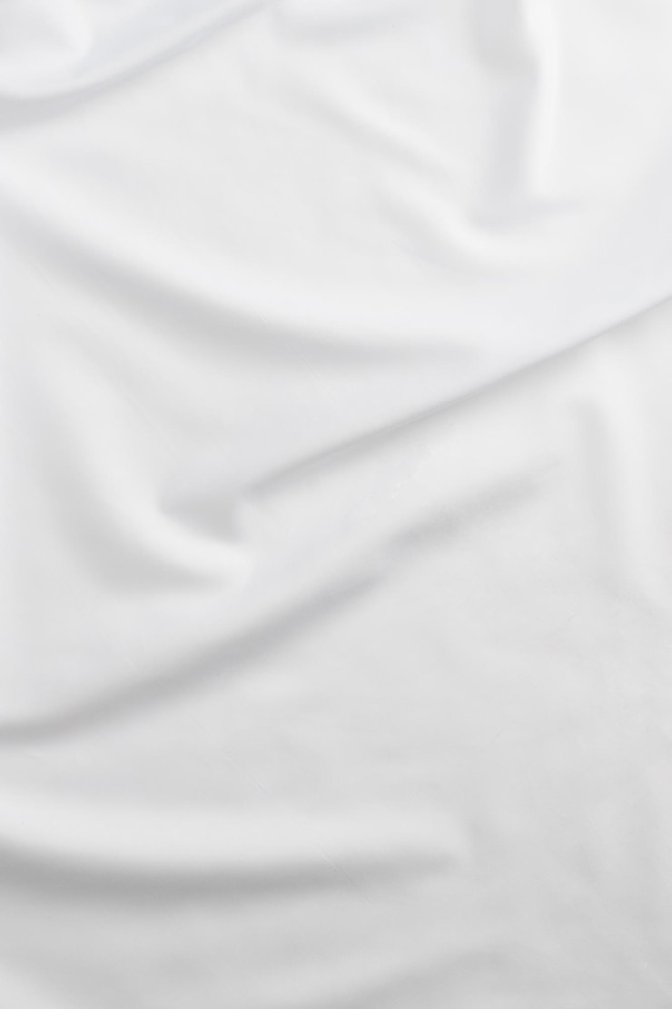 Photo white cotton fabric draped bed linen