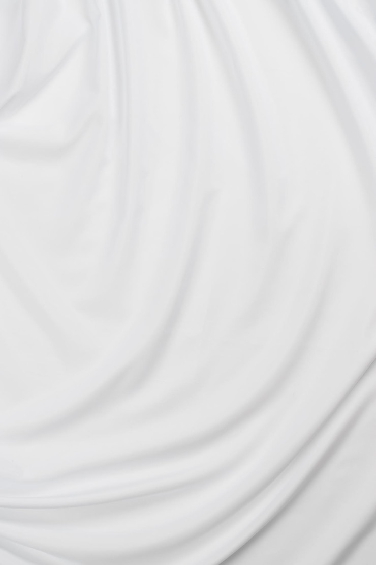 Photo white cotton fabric draped bed linen