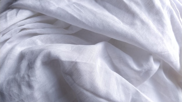 White cotton fabric not ironed and crumpled in waves White background Tablecloth or sheet