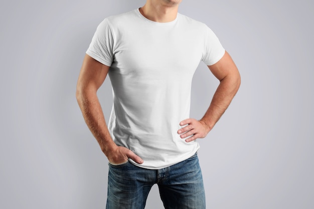 white cotton T-shirt on a young guy posing on a gray wall.