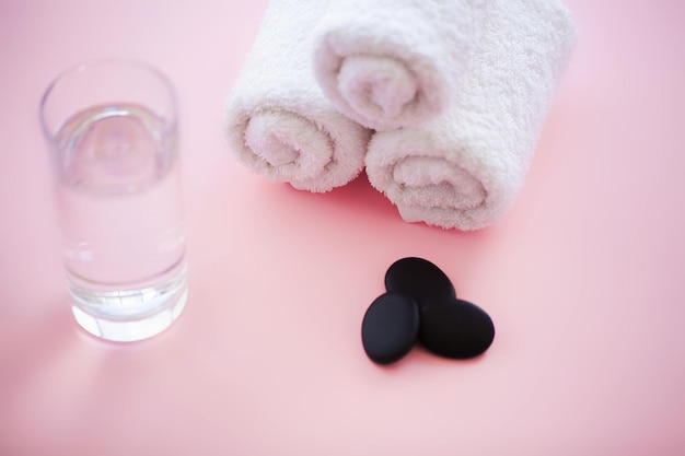 Белые хлопковые полотенца используют в спа-ванной на розовом фоне