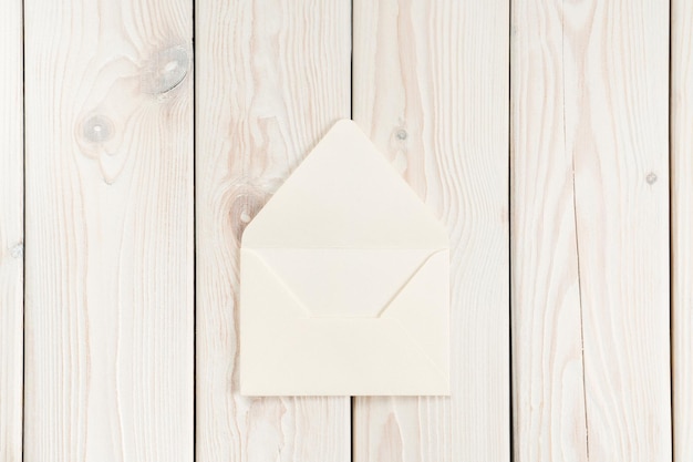 Photo white craft handmade opened paper envelope laying on white wooden plank background post card message letter sending