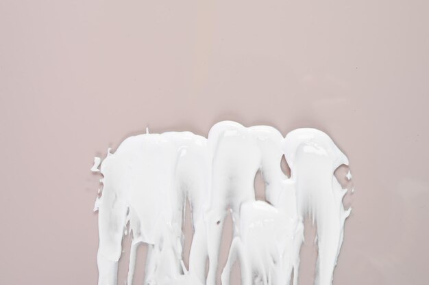 Белый крем на пастельном фоне мазок и текстура крема Косметика для лица и тела образец крема Концепция ухода за кожей Фото высокого качества