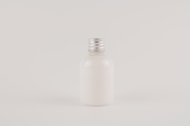 White cream in a transparent jar on a white background