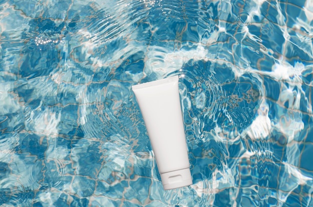 White cream tube mock up in swimming pool background sunscreen body skin care concept