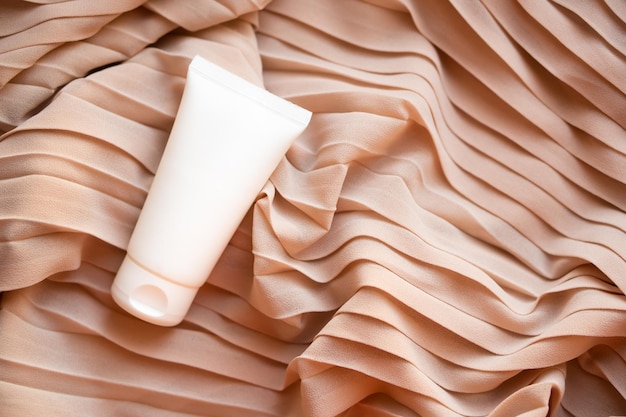 White cream tube mockup on textile background