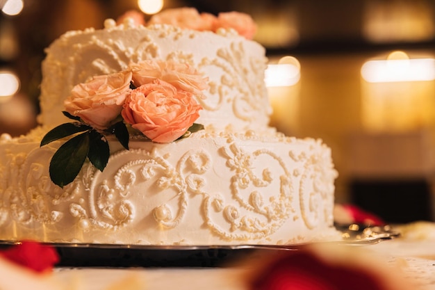バラのつぼみで飾られた白いクリーミーなケーキ。