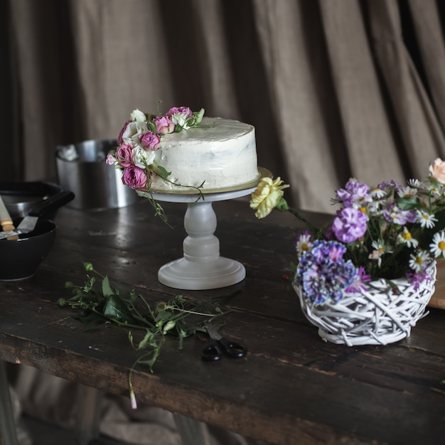 Foto torta cremosa bianca decorata con rose su sfondo scuro