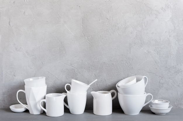 White crockery on the table against the textured grey wall