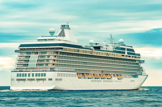 White cruise liner moving to the sea at cloudy day