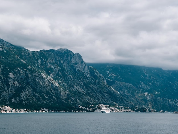 White cruise liner sails along the mountainous coast of the sea