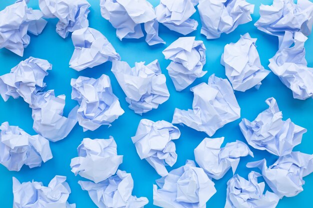 White crumpled paper balls on a blue background.