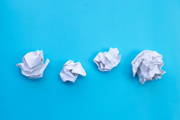 White crumpled paper on blue background