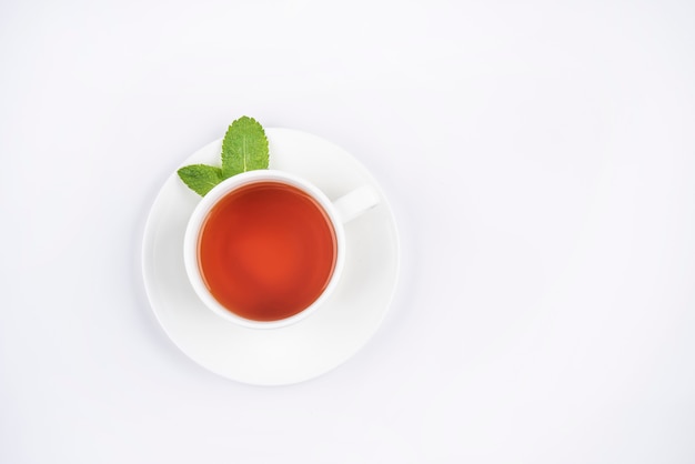 White cup of black tea with leaves mint isolated top view copy space