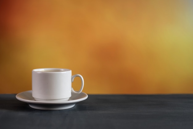 White cup of coffee on colorful background. With copy space.