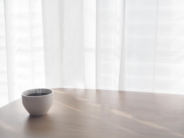 white cup of coffee on wood table.