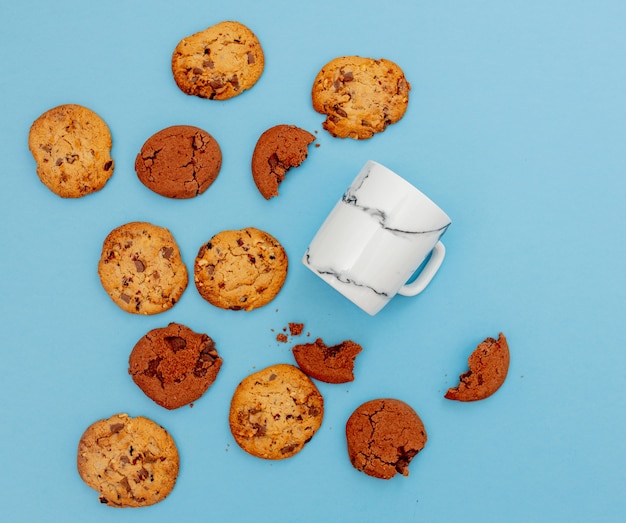 White cup and cookies on blue background