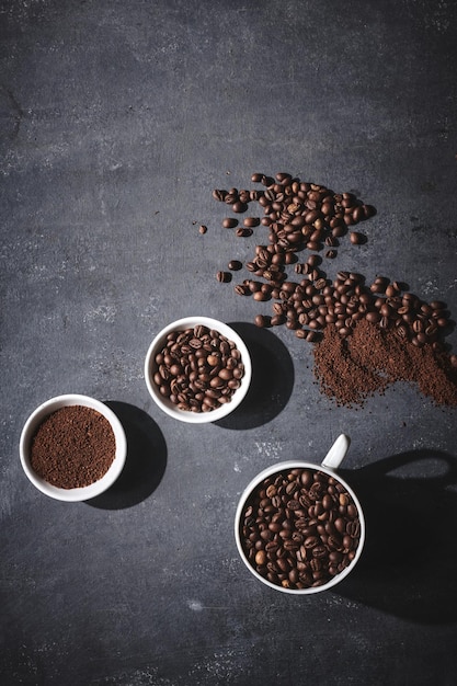 Tazza bianca di chicchi di caffè tostati appena preparati su sfondo grigio