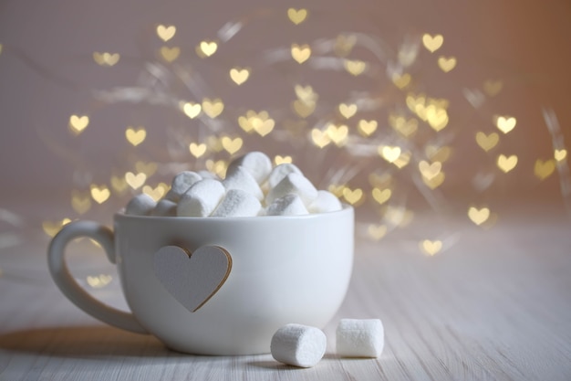 White cup, heart, lights and marshmallow