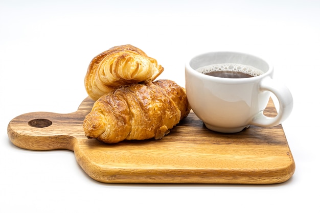 A white cup of hot coffee with croissant on wooden tray isolate on white background.