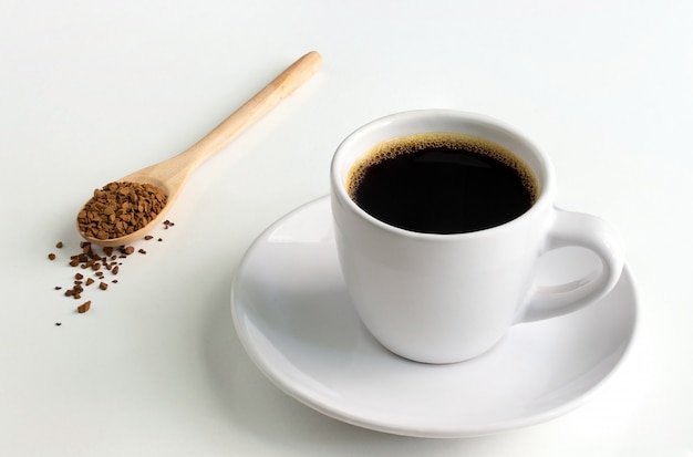 White cup of hot coffee and a wooden spoon