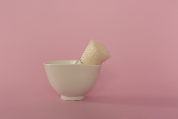 In the white cup is a makeup brush.