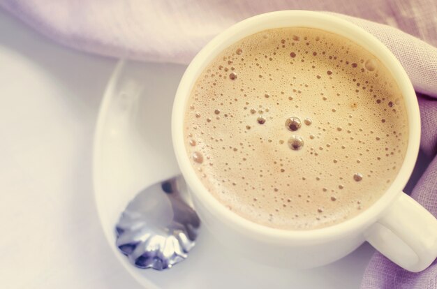 朝のコーヒーまたはカプチーノの白いカップ。