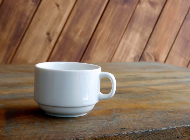 white cup on table on wooden background