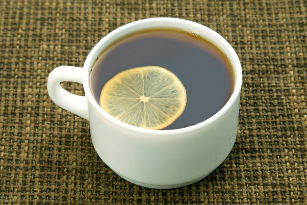 White cup of tea with lemon . hot drink