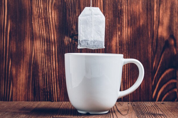 A white cup of tea with a tea bag