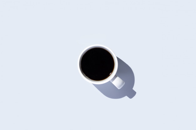 White cup with a coffee on a isolated light space. top view, flat lay