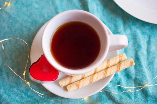 コーヒーまたは紅茶と赤いハートの白いカップ