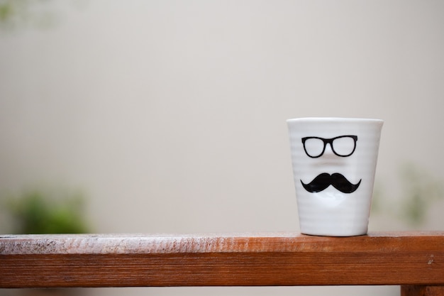 White cup with man face